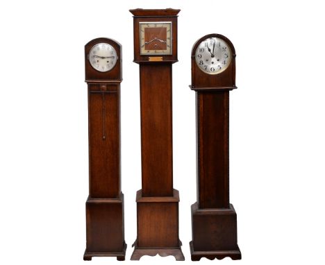An oak dwarf longcase clock, c1930, the square dial with silvered chapter ring, 133cm h and two contemporary smaller examples