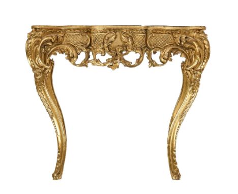 A giltwood console table, 19th c, the apron to the serpentine top with blind trellis and open scrolling foliage on scrolling 