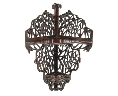 A Chinese carved hardwood corner shelf, early 20th c, with bamboo and flowers, 69cm h  Minor losses to carving (split on one 