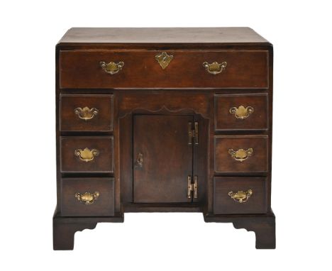 A George III oak kneehole desk, with caddy moulded top and fitted with secretaire, above apron drawer and cupboard, flanked b