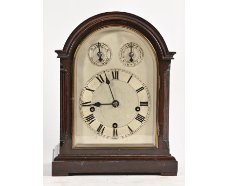 A German mahogany clock, c1900, the arched, silvered dial with chapter ring and twin subsidiary rings, the arch having Winter