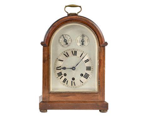 A German mahogany-stained wood clock, c1900, the arched, silvered dial with chapter ring and two subsidiary rings to the arch