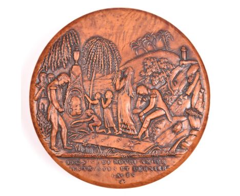 A circular carved fruitwood patch box, the lid carved with the scene of Napoleon’s burial on St. Helena, with weeping figures