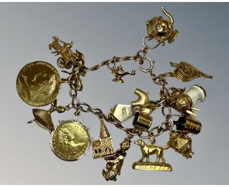 A 9ct gold charm bracelet set with many charms and two silver-gilt coins, 69.6g.