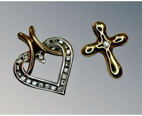 A gold heart pendant set with diamonds and a gold crucifix set with a diamond.