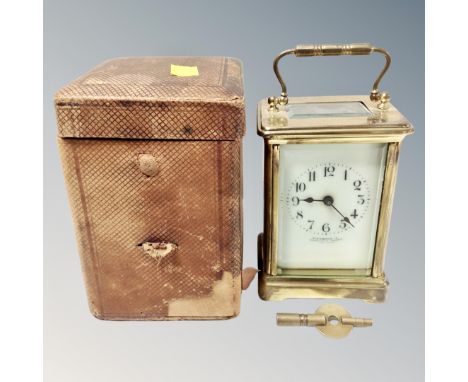 A brass carriage clock with key, in travel case 
