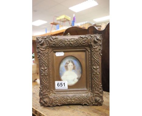A miniature portrait of a young girl in an ornate gilt frame