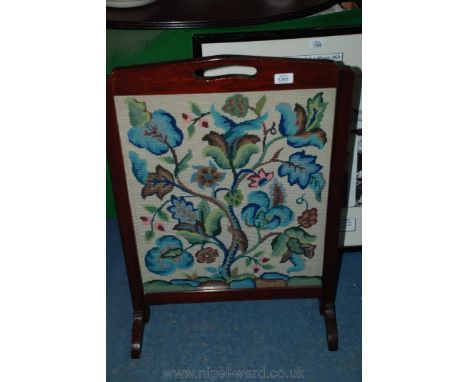 A stained Oak framed Firescreen, with fret cut handle and rectangular frame containing floral tapestry display under glass an