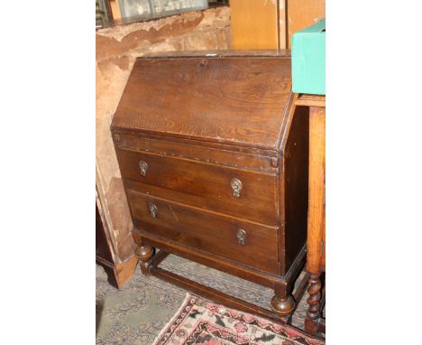 A 1940's Oak Bureau with plain top, the moulded fall opening to reveal six ply lined pigeon holes, manual lopers over two low