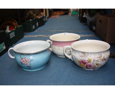 Three chamber pots, one blue with apple blossom, pink and gold coloured pot and a thistle design pot