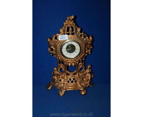 An ornate decorated gilt effect West German mantle Clock with lady and gentleman sat on steps of bandstand, slight damage to 
