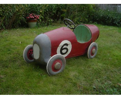 A rare and early tinplate pedal car, possibly Tri-ang in the form of a single seater 1920s racing car.