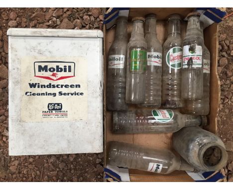 A collection of assorted oil bottles including Mobiloil and Castrol and a Mobil Windscreen Cleaning Service paper towel dispe