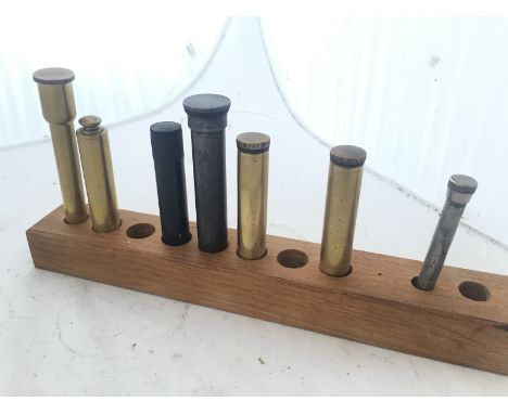 A collection of brass cylindrical cased tools. 