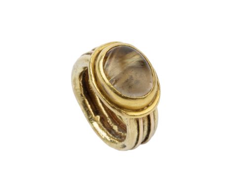 An 18ct gold and rutilated quartz set ring, the oval stone set in a heavy reeded setting and shank, maker C.H, London 2000Ove