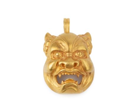 A 22k gold demon mask pendant and brooch, the half-human face with open jaws and fangs, the hinged bale stamped 22k, 5cm high