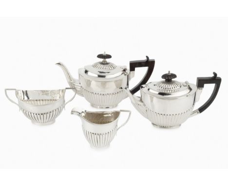 A late Victorian three piece bachelor's tea service, of half lobed form, the teapot with ebonised handle and knop, by Thomas 