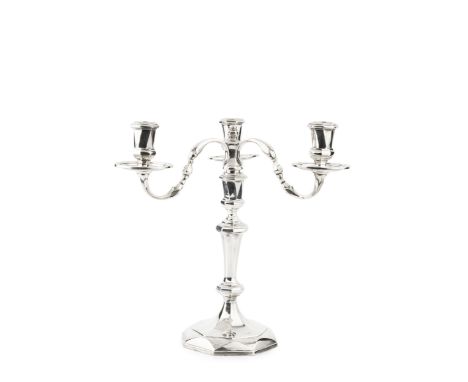 A silver three light candelabrum, the detachable branches with shaped arms, faceted nozzles and reeded drip pans, having tape