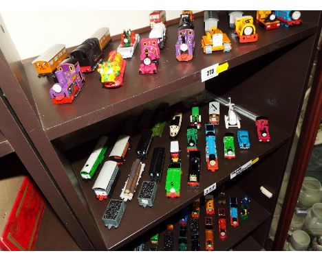 A large quantity of Thomas the Tank Engine by ERTL locomotives and rolling stock displayed on three shelves, approximately 60