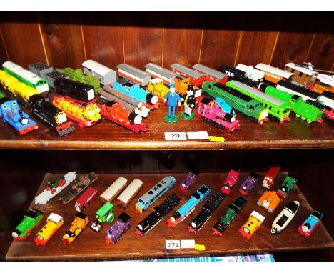 A large quantity of Thomas the Tank Engine by ERTL locomotives and rolling stock displayed on two shelves, approximately 60 p