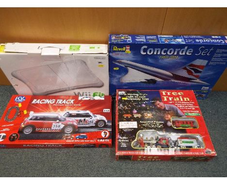 A Nintendo Wii Fit balance board, boxed, a tree train with animated engine, boxed, a Whitehouse racing track with stitch elec