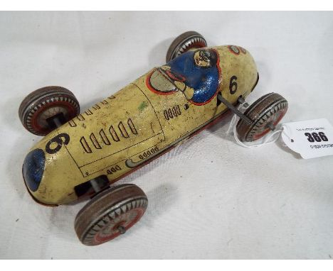 A rare Mettoy tinplate Clockwork Racing Car - early post war model finished in light tan with detailed tinprinting including 