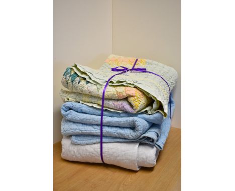 Three vintage cotton handmade quilts, including a patchwork example having a striking star motif at the centre, in pale paste