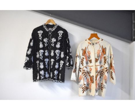 Two 1960s-1970s The Foreign Look embroidered jackets. A Black cotton jacket with intricate vut-out design, and white floral a