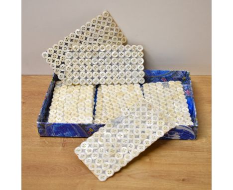 A quantity of vintage freshwater-shell shirt buttons, held in place on silver card with green thread, approximately 80+ in nu