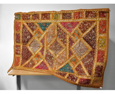 A vintage wall hanging in the African / Middle Eastern style, having yellow-orange, brown, red and azure background panels ov