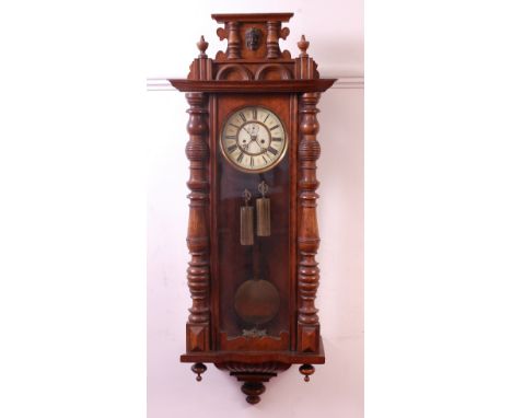 A late 19th century walnut and stained beechwood cased Vienna droptrunk wall clock, the white enamel dial with subsidiary sec