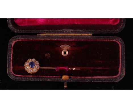 A Victorian yellow metal sapphire and diamond set stick-pin, arranged as a centre claw set sapphire in a surround of eight sm