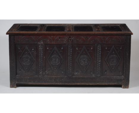 A circa 1700 joined oak four panel coffer, having replacement ironstrap hinges and with lozenge and rosette flower head blind