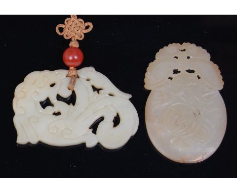 A Chinese pierced celadon jade plaque, engraved in the form of a seated kylin, w.7cm; together with a Chinese pierced and eng
