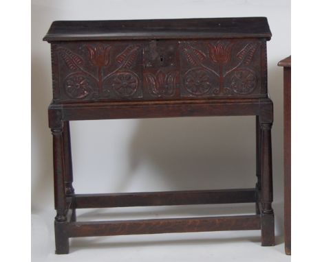 A circa 1700 oak Bible box, having twin stylised flower head carved panel front within chip carved corners, the whole on late