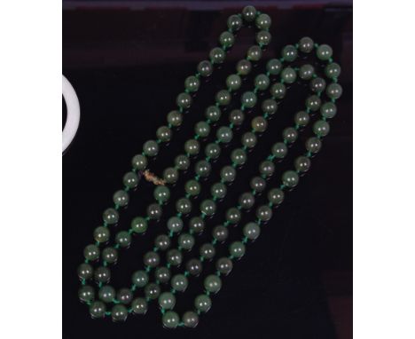 A spinach jade beaded and knotted long necklace, each bead dia 9mm, gross length 124cm