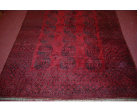 A Persian woollen Bokhara carpet, the red ground decorated with three rows of octagonal medallions within multiple continuous