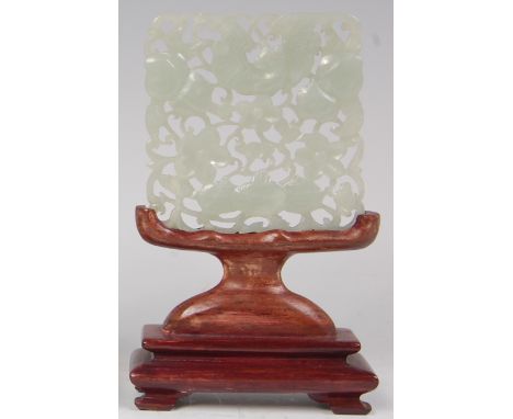 A Chinese celadon jade carving of a winged dragon amidst flowers and foliage, on wooden stand, w. 7cm Condition Report / Extr