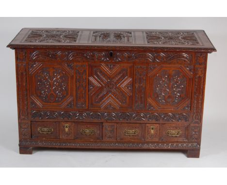 An 18th century and later relief carved oak three panel mule chest, having hinged lid and two lower drawers, h.78.5cm, w.134c