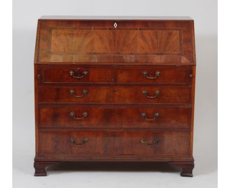 A George III mahogany and satinwood strung bureau, the hinged fall revealing a fitted interior above two short over three lon