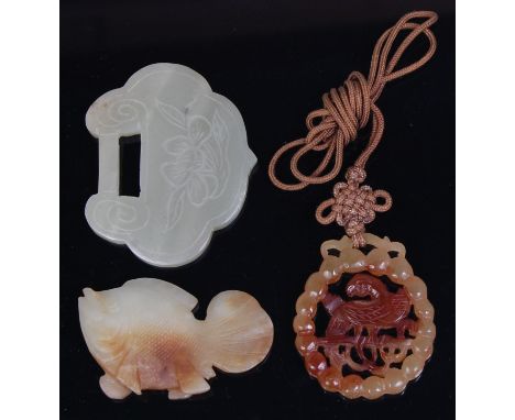 A Chinese engraved celadon jade plaque, in the form of a lockplate, with floral decoration opposing four character marks, w.6
