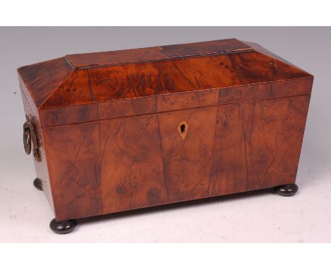 A 19th century yew wood veneered tea caddy, of sarcophagus form, the interior having twin lidded compartments flanking centre