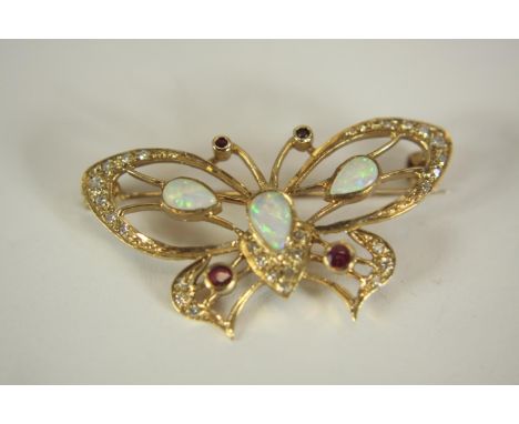 A 9ct yellow gold, opal, diamond and ruby openwork butterfly brooch. The brooch set with three opal cabochons with a combined