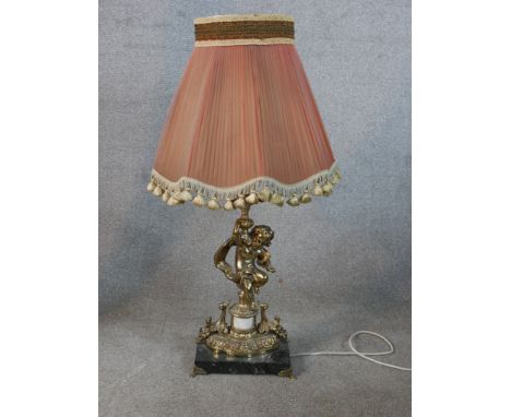 A 20th century cast brass cherub table lamp standing on square marble base, raised on four brass feet. H.79 W.42 D.38 