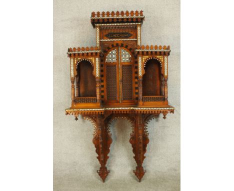 A 20th century bone inlaid hardwood, probably from Rajasthan, wall hanging shelf unit with central twin doors flanked by shel