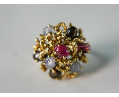 A 14 carat yellow gold and ruby and star sapphire abstract form dress ring. The ring set three Ceylon star sapphire cabochons