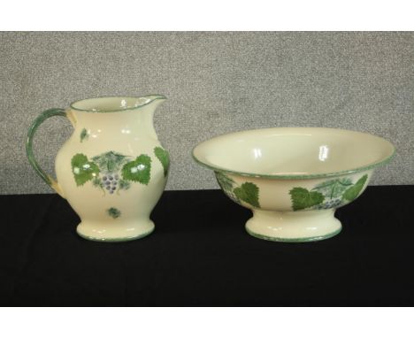A 20th century Poole Pottery 'Vineyard' jug and bowl set, decorated with grapes and vine leaves. H.26 W.28 D.21cm. (largest) 
