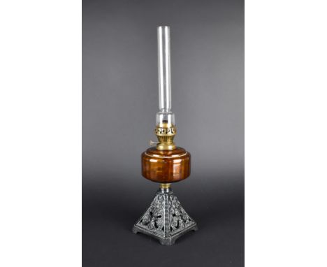 A Late Victorian/Edwardian Cast Iron Based Oil Lamp with Amber Glass Reservoir and Plain Chimney, the Base Decorated in Relie