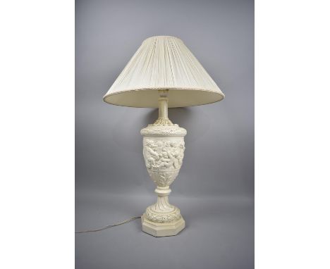 A Moulded Composition Vase Shaped Table Lamp in the Italian Style with Cherub Decoration in Relief, with Shade, 65cm high 