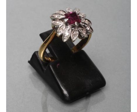 A RUBY AND DIAMOND CLUSTER RING, the square facet cut ruby claw set to a petal border set with numerous small diamonds to a p